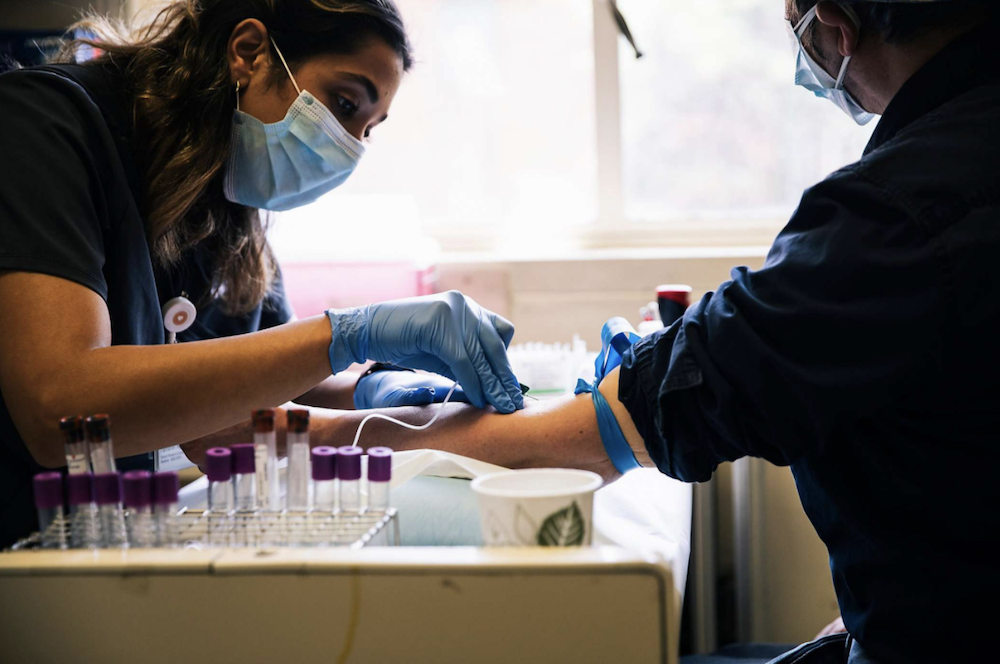 Phlebotomist drawing blood from research participant